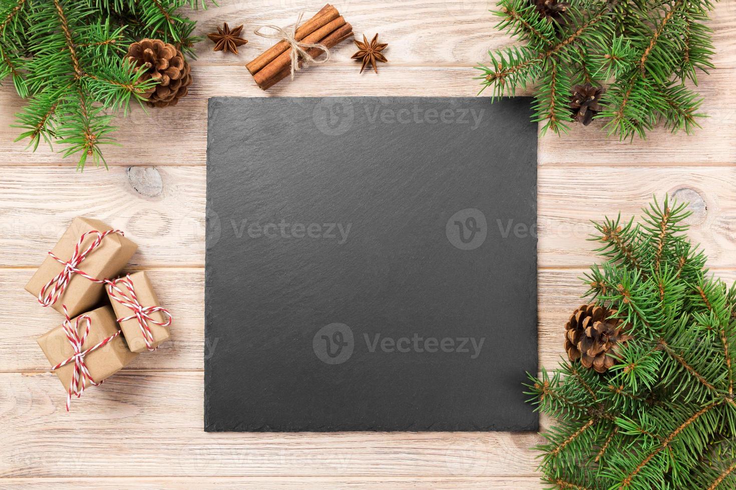 Slate blackboard on wooden table with christmas decoration. black slate stone on wooden background. copy space. New Year concept photo