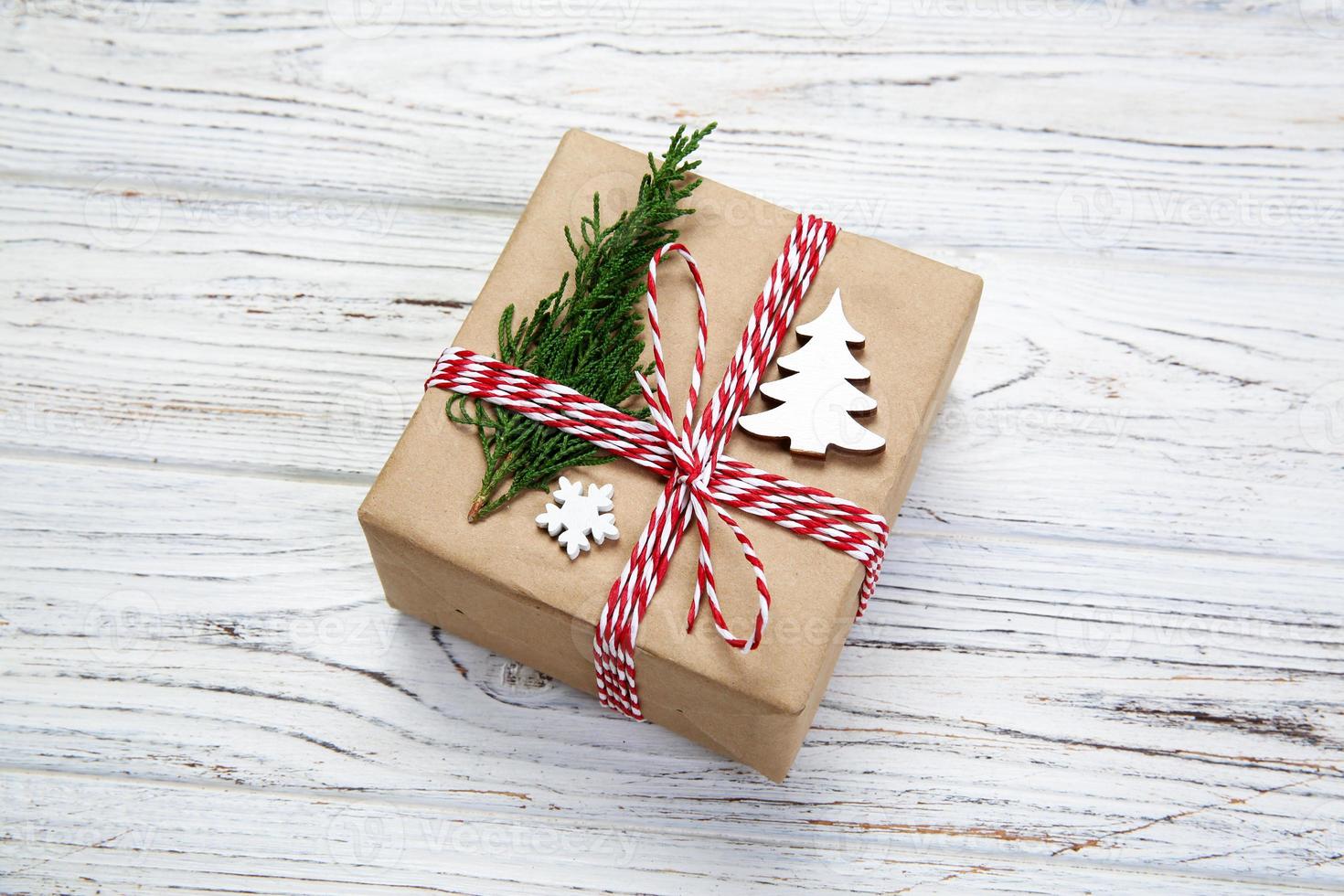 Christmas gift box wrapped in recycled paper, with ribbon top view with copy space on rustic background. Holiday concept photo