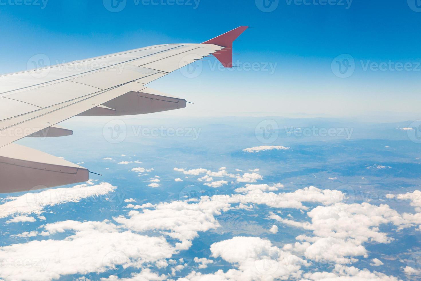 view from the window of the plane that flies over the mountains photo