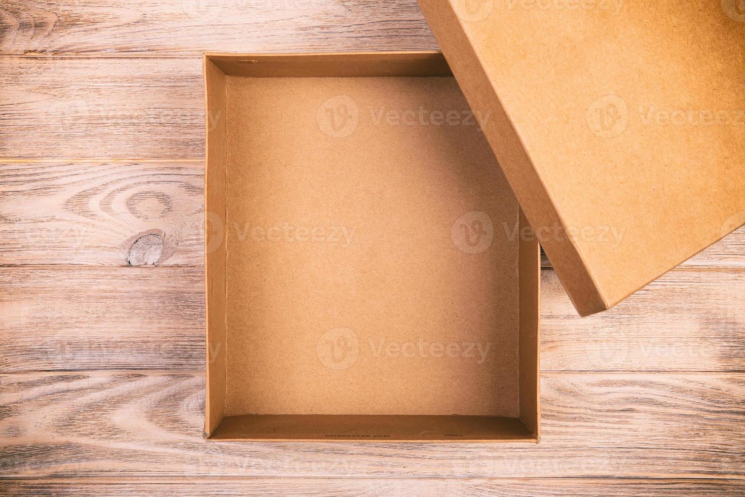 Opened cardboard box on a wooden table. vintage, toned top view photo