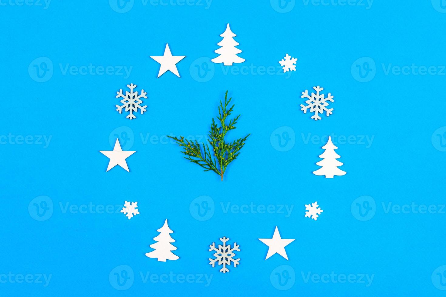 Concept clock made of christmas decoration showing five to midnight New Year on blue background with copy space photo