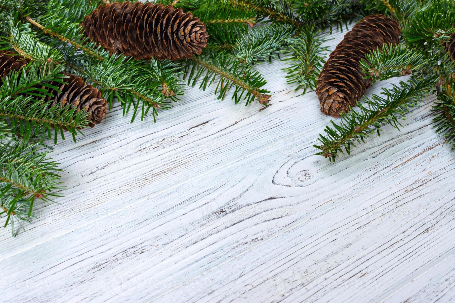 Christmas background. Fir tree branch pine cones at wooden table. Flat lay, space for text photo