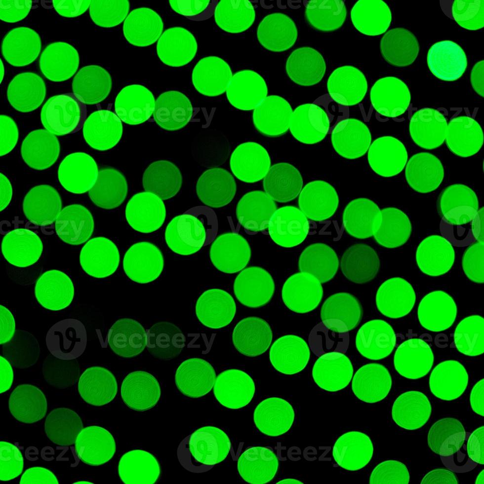 Unfocused abstract green bokeh on black background. defocused and blurred many round light photo