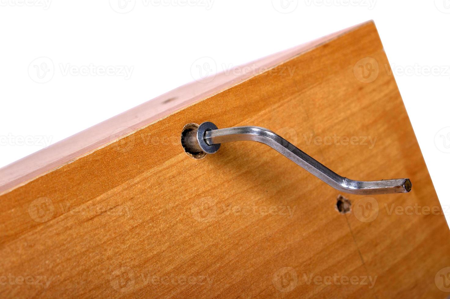 Hand of the worker screws in a wooden block photo