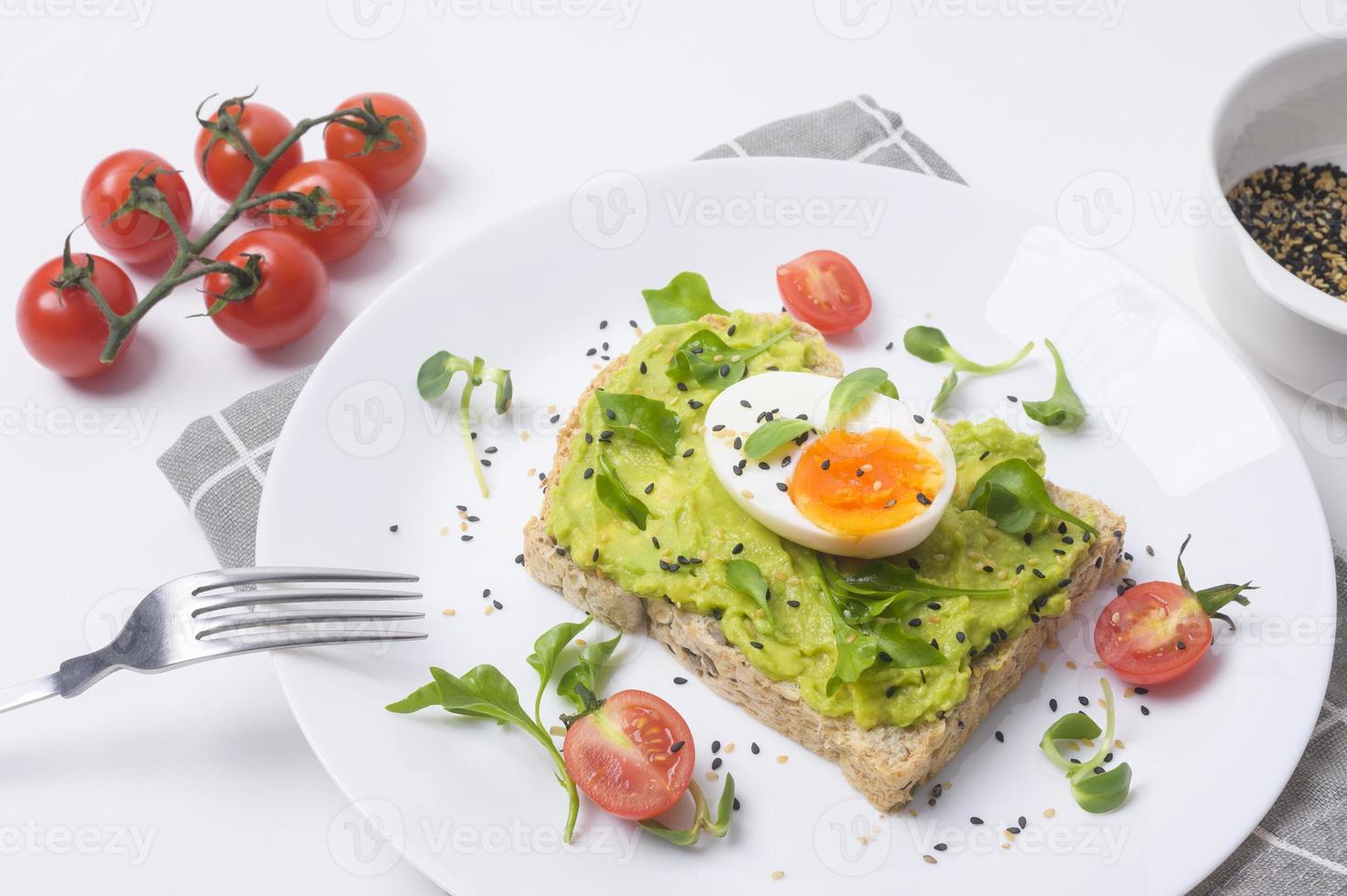 pan con aguacate, verduras, frutas y huevo sobre fondo blanco, concepto de desayuno saludable foto