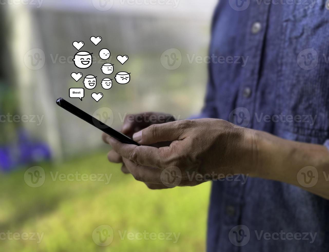 Social media and digital online concept, man using smart phone. The concept of living on vacation and playing social media. Social Distancing ,Working From garden photo