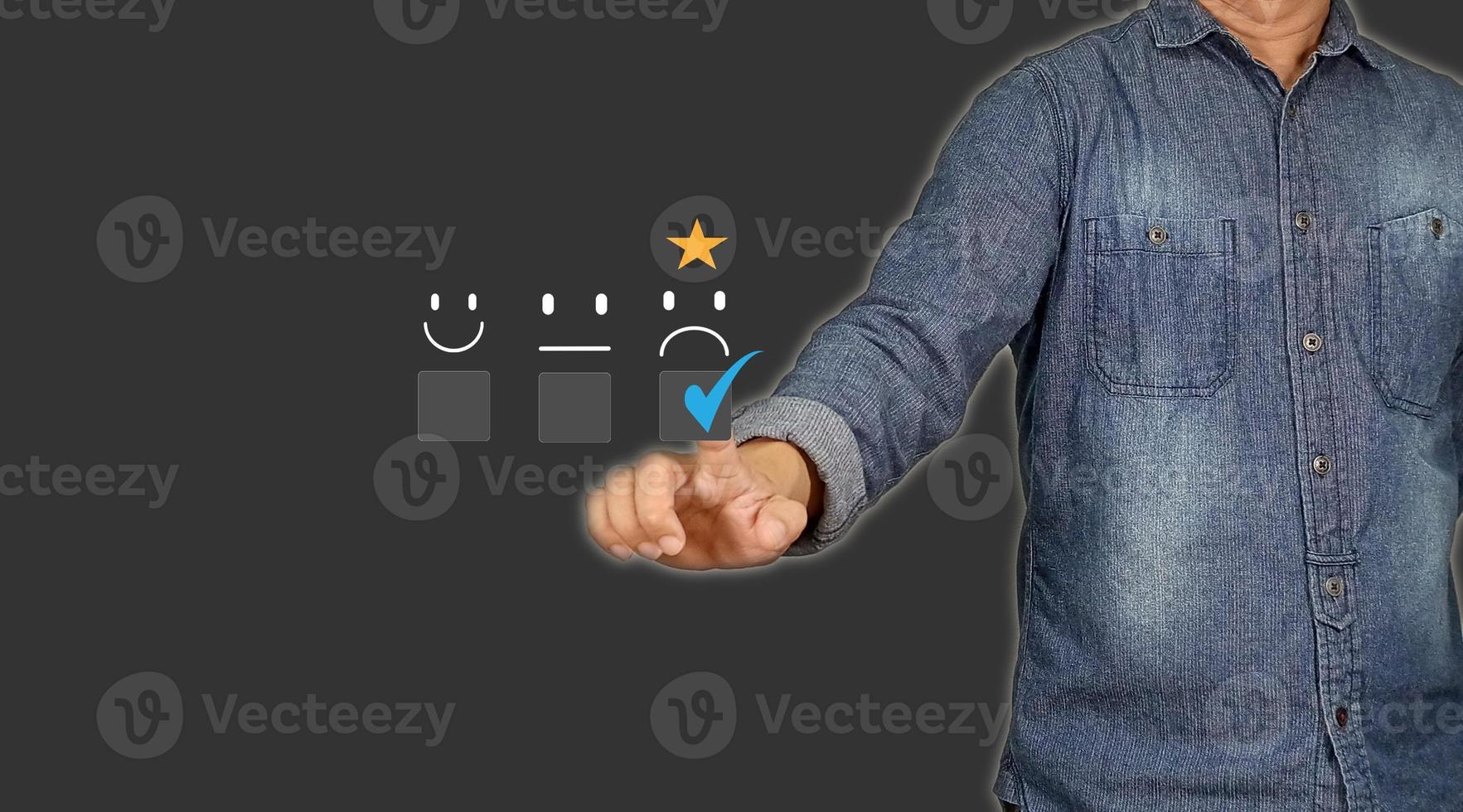 Customer Service and Satisfaction Concept Businessman touching virtual screen on unhappy face icon to express dissatisfaction with service Very bad rating. Gray background with empty space. photo