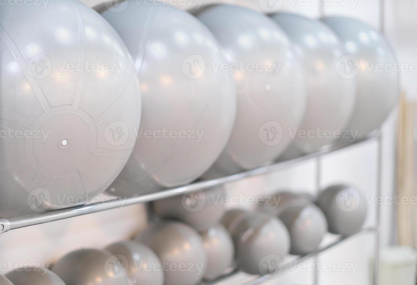 physical therapy fitballs on a shelf in a rehabilitation center. pilates and post traumatic exercises equipment. back pain care, stretching and workout photo