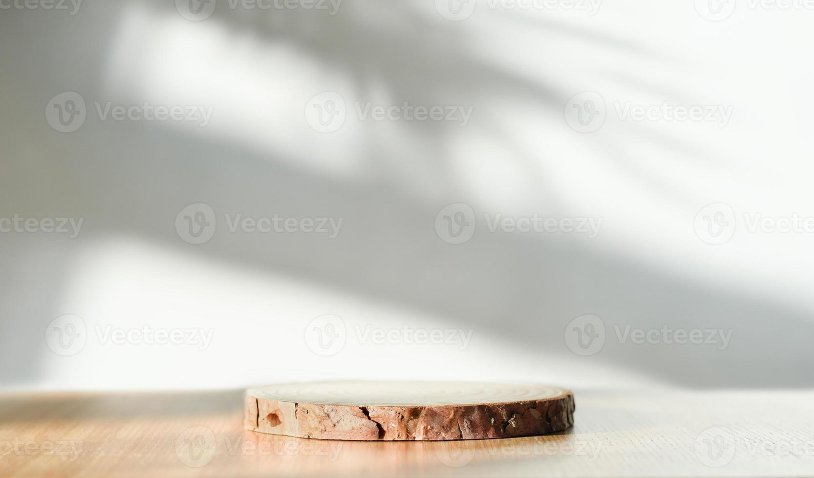 empty wooden round podium on a table and shadows on a wall. copy space for product presentation and sale promotion. photo