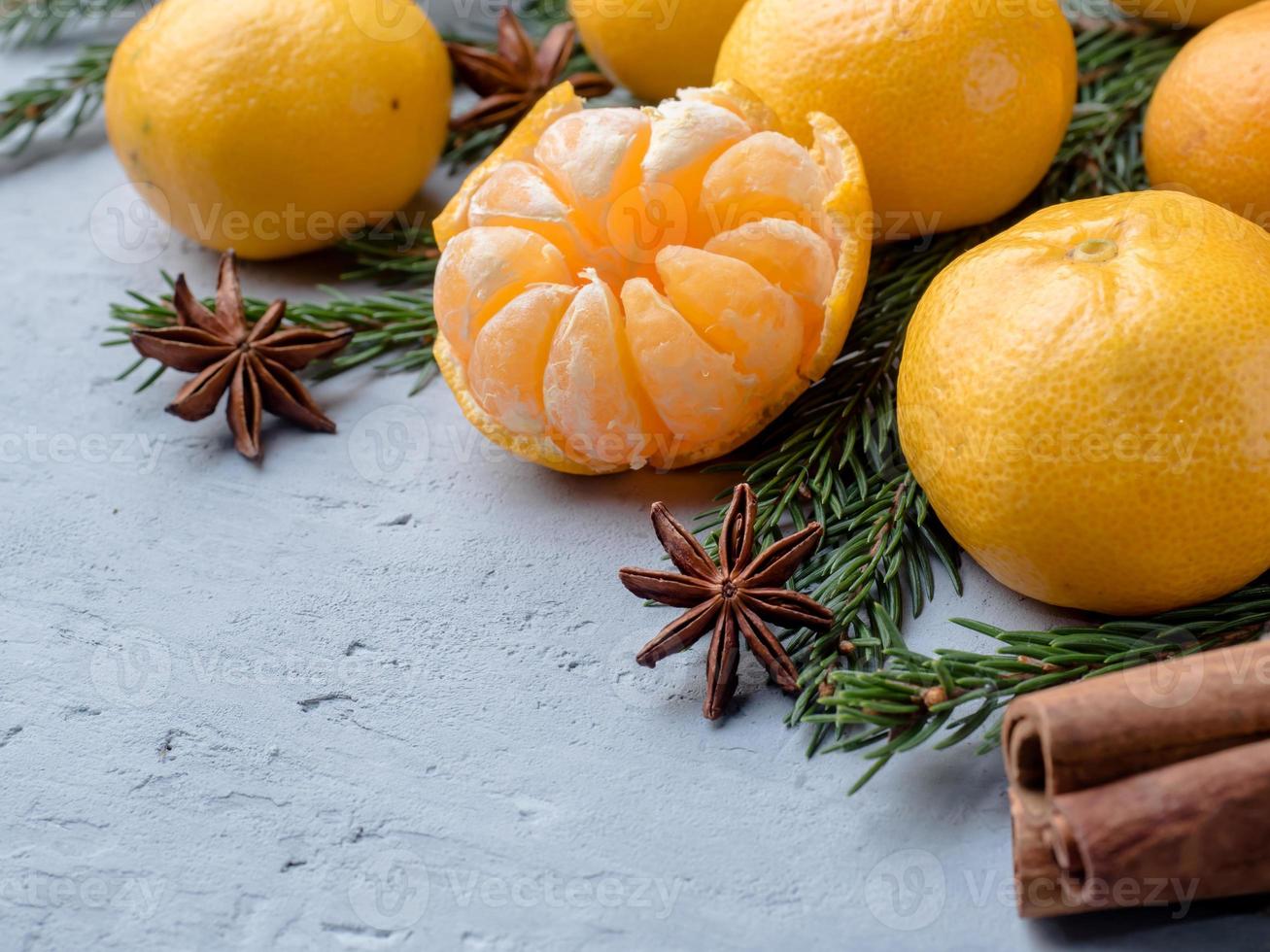 Fresh tangerines with branches of Christmas tree, star anise cinnamon on gray concrete background Copy space photo