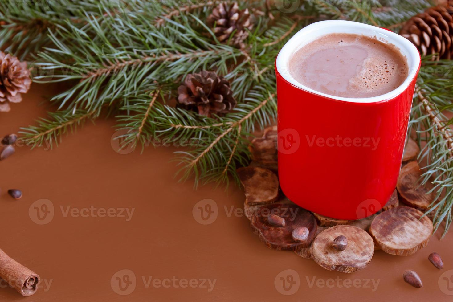 Christmas traditional hot drink cocoa in red cup, fir branches and cones on the dark wooden background copy space photo