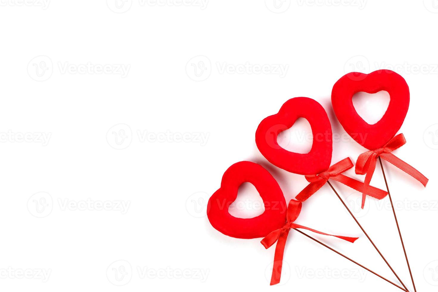 Three red hearts with bows on a white background. Isolate photo