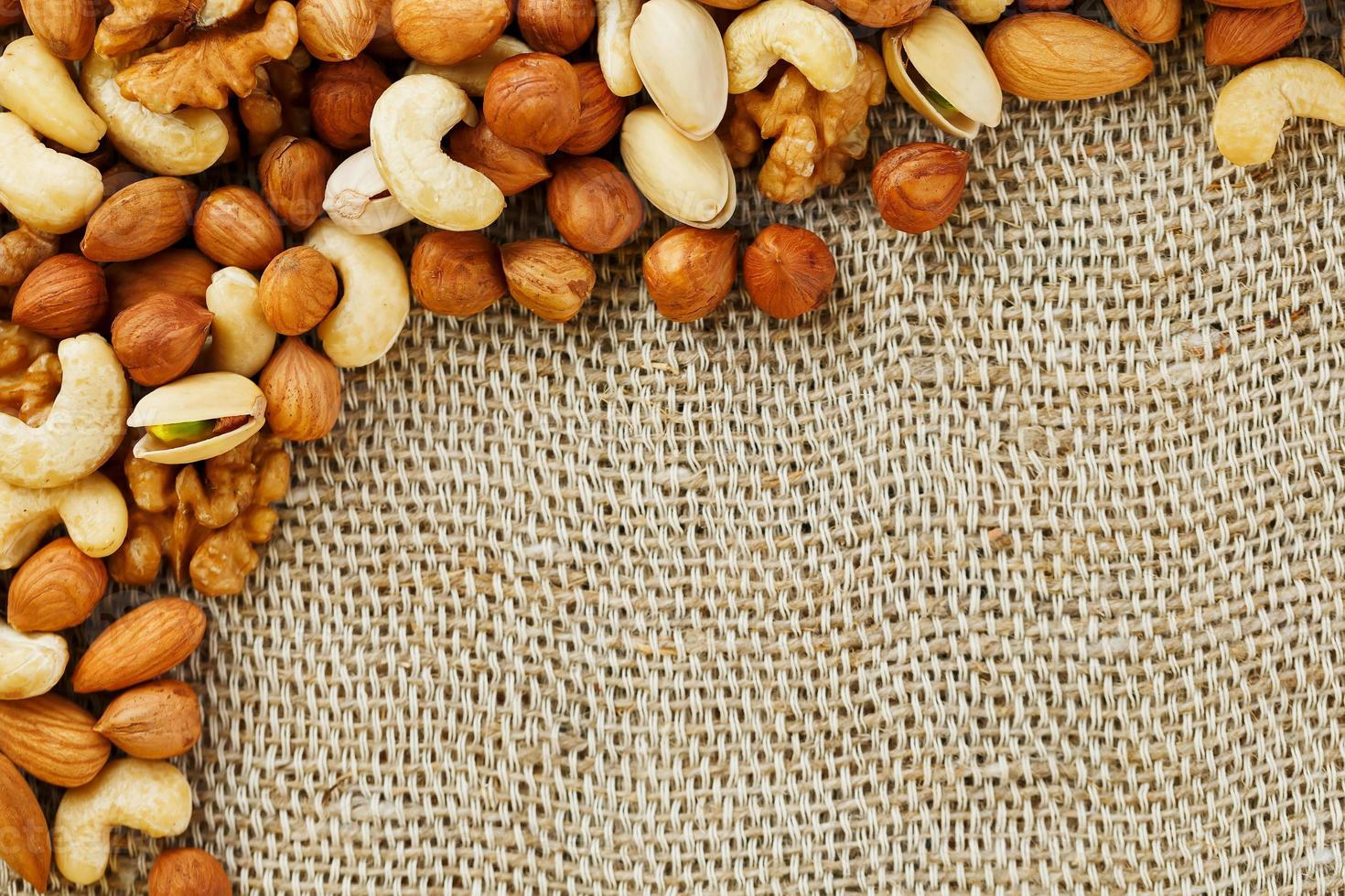 Mix of nuts lying on a background of brown cloth burlap. photo