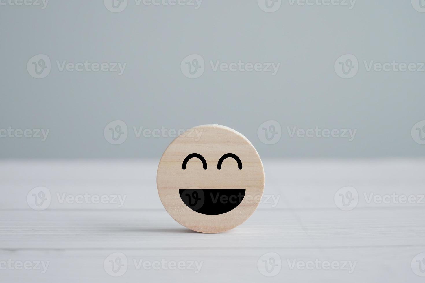 Happy face on wooden circle. Enjoy life. Positive thinking, feedback, emotion, Satisfaction, Customer service review, Mental health assessment, World mental health day concept. photo