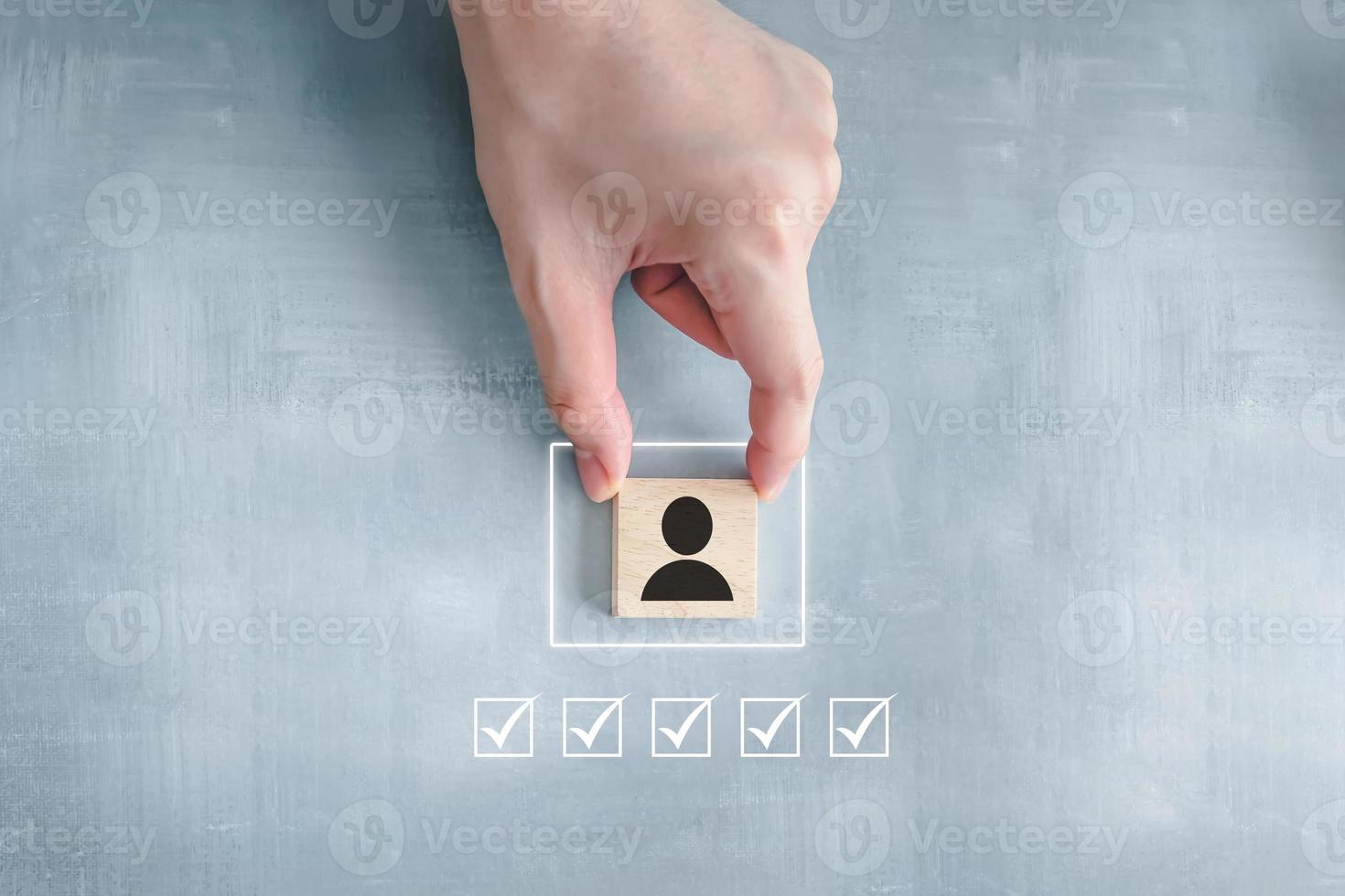 Business hiring and recruitment selection. Career opportunity. Human Resource Management. finding leader or new employee. Hand choosing human icon on wooden block with tick all check mark. photo