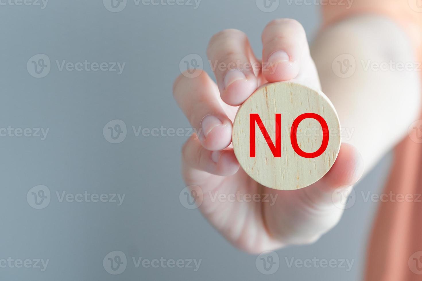 Think With Yes Or No choice.Test question. Choice hesitate, opposition, opponent view. making decision. Woman hand showing No word on wooden circle for expressing rejection or stop symbol. photo