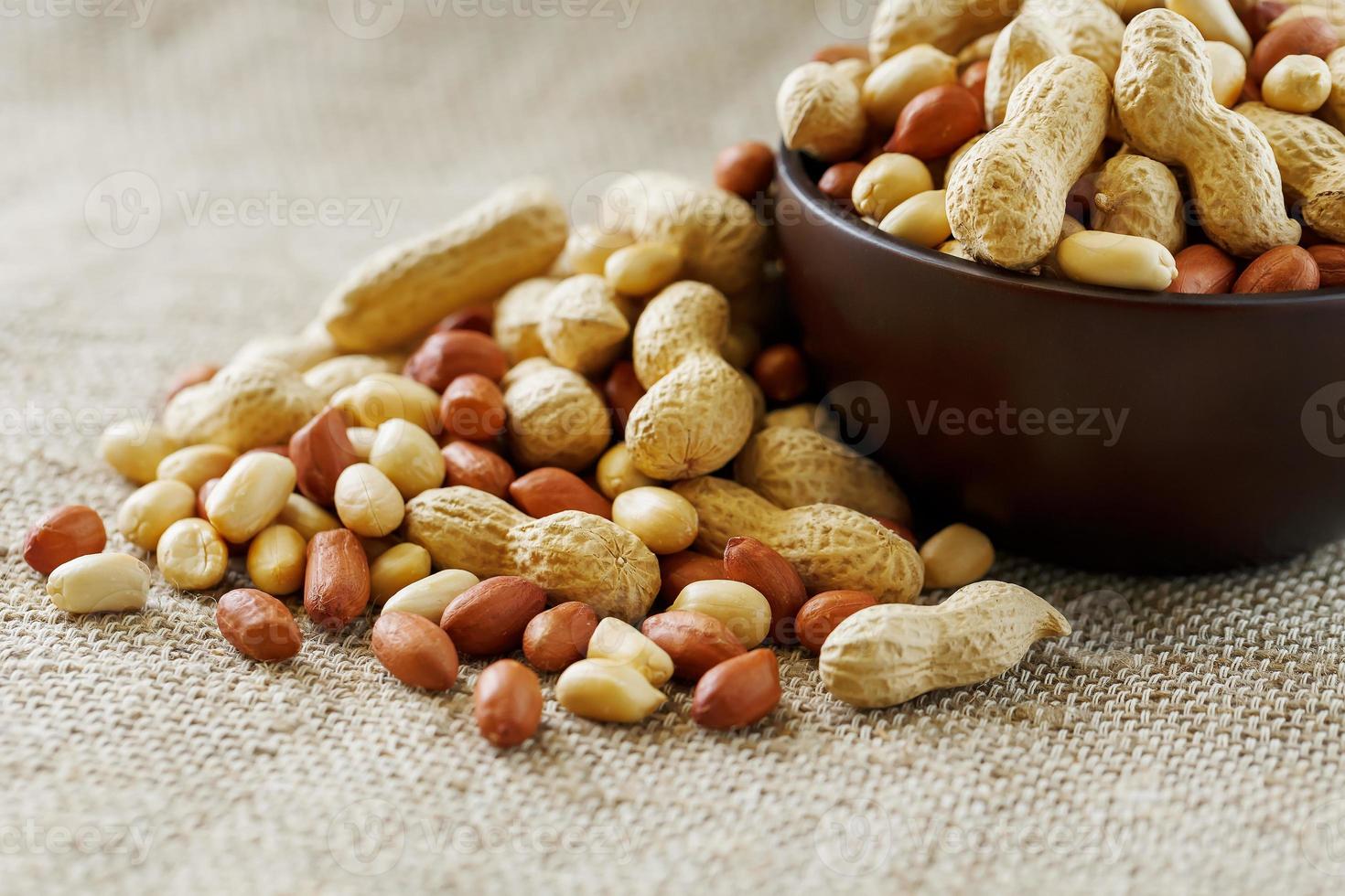 Peanuts in the shell and peeled closeup in a cup photo