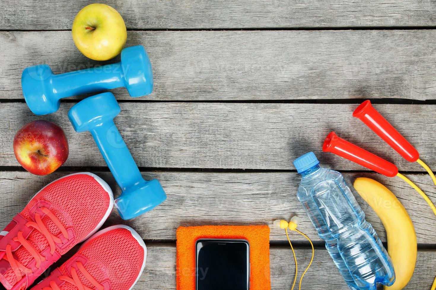 Sports equipment and the smartphone with earphones on a wooden background photo