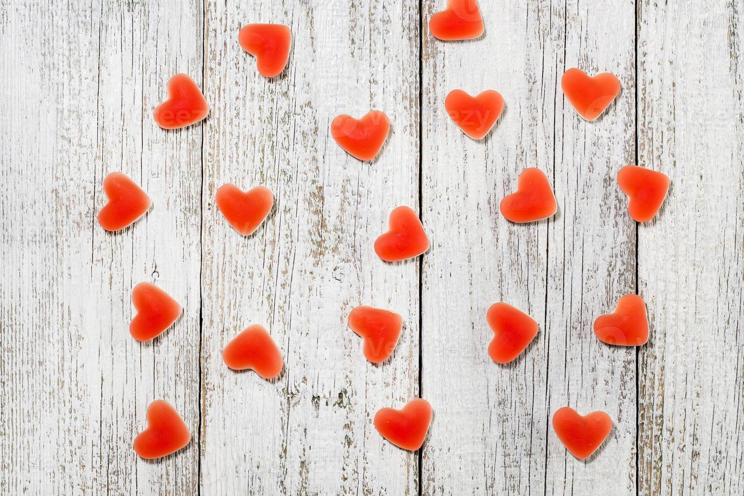 patrón de caramelos de gelatina en forma de corazón sobre fondo blanco de madera foto