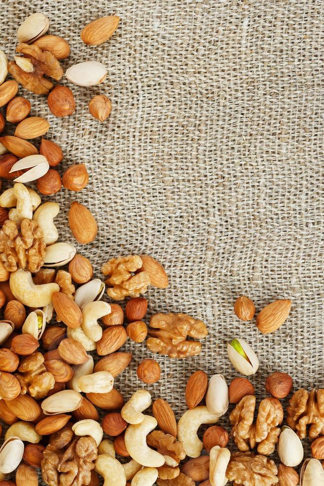 Mix of nuts lying on a background of brown cloth burlap. photo