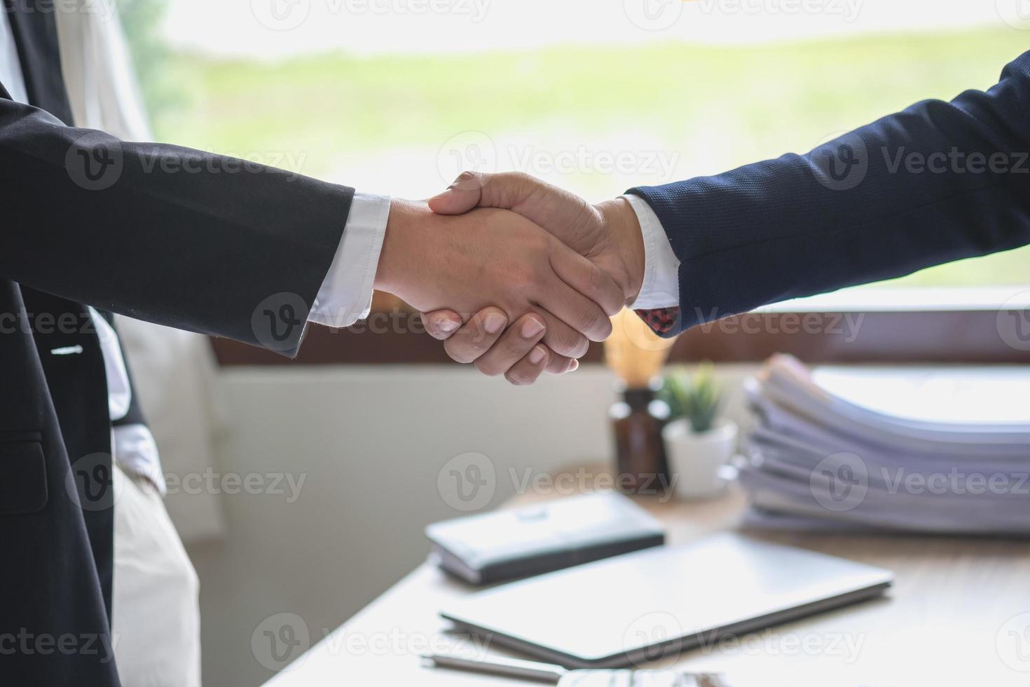 dos hombres de negocios se dan la mano para la cooperación empresarial foto