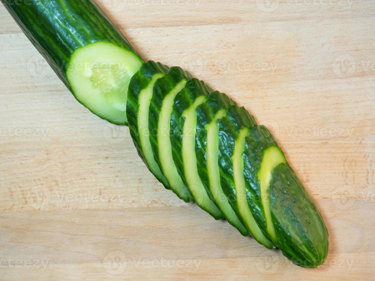 A smooth, medium-sized cucumber cut into slices. Cucumber on a cutting board. Vegetable isolate. Fresh ripe vegetable photo