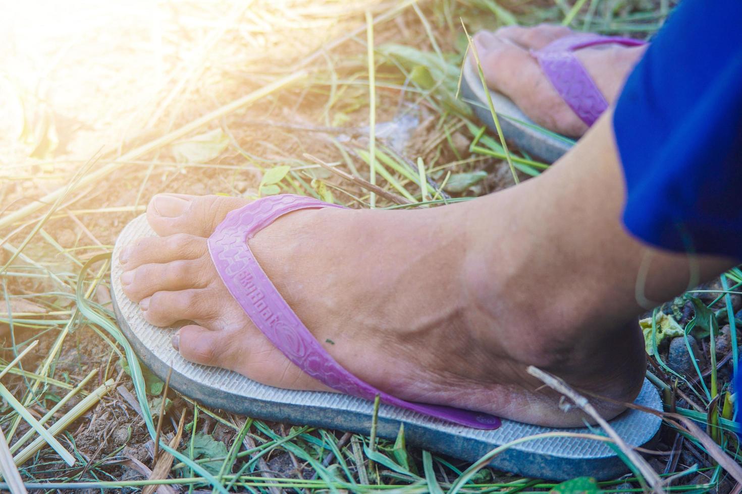 one hand a man holding a cigarette blurry sickle background and flip-flops photo