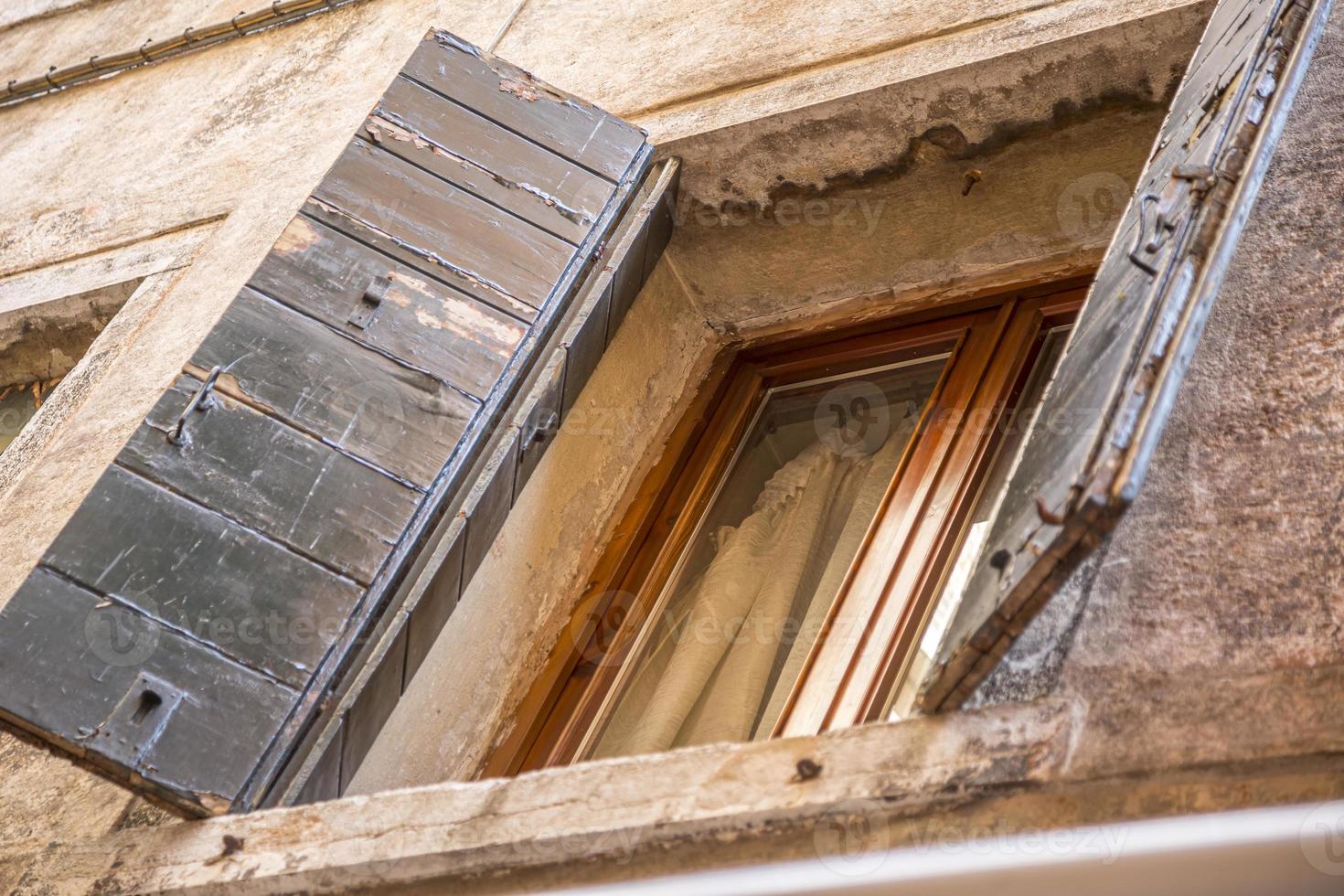 Window with brown shutters on the window sill in Italy. photo