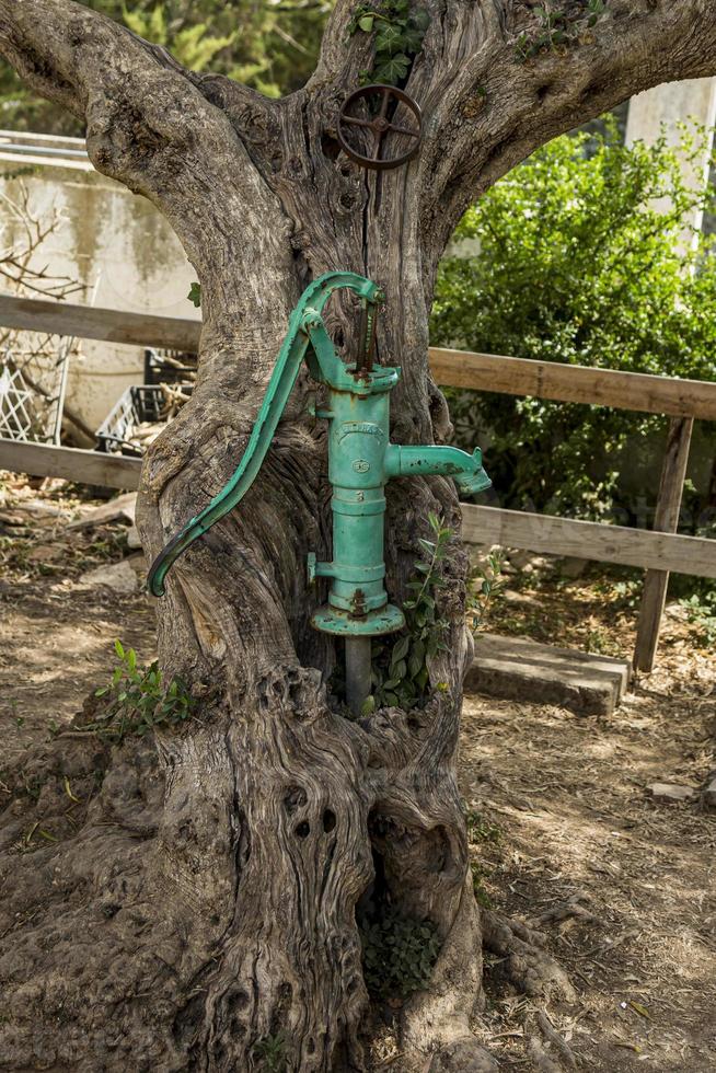 bomba de agua de mano antigua en un pozo en el jardín, riego y ahorro de agua en austria. foto