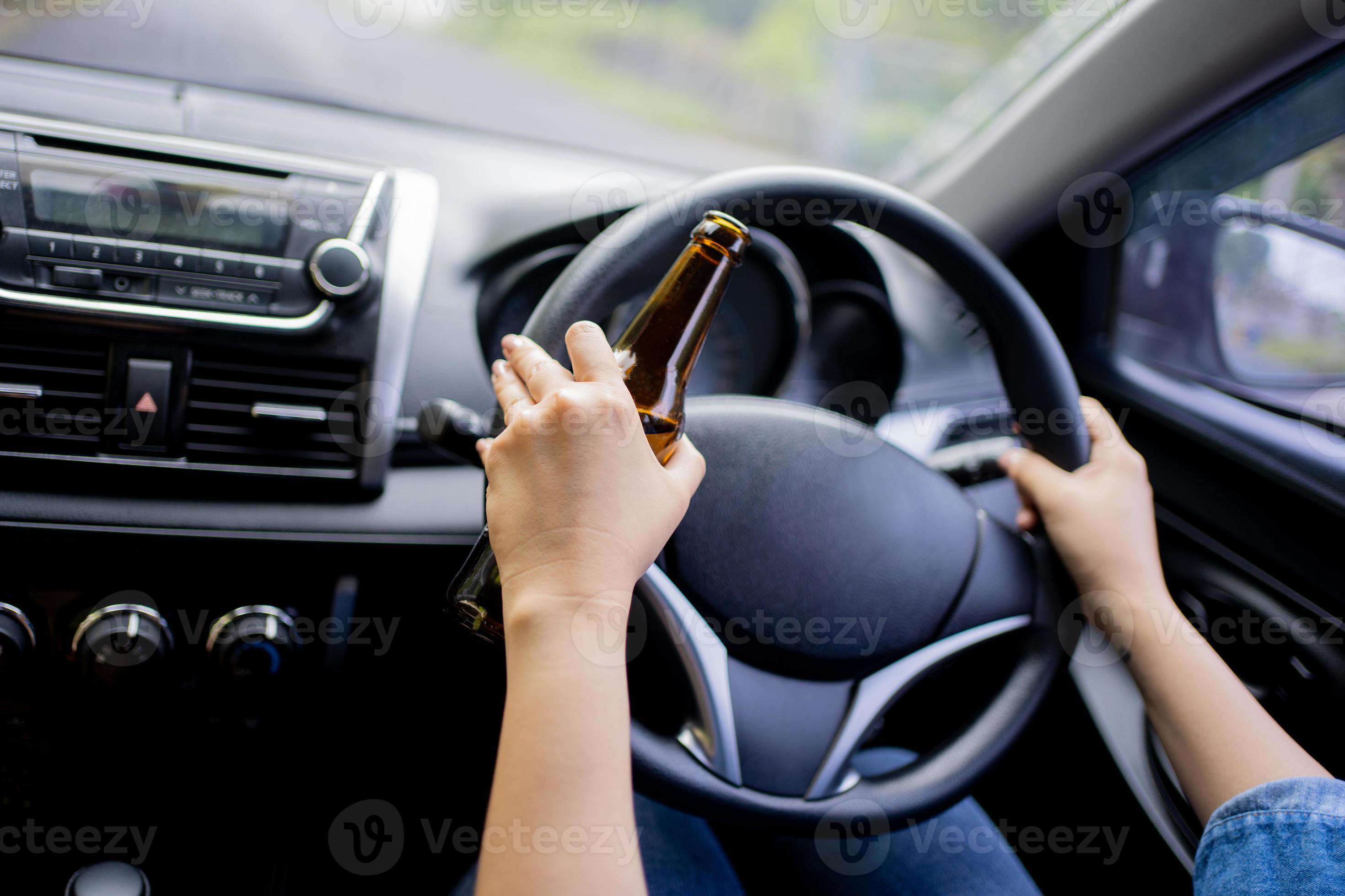 Woman drink beer while driving car. Driving in a state of intoxication