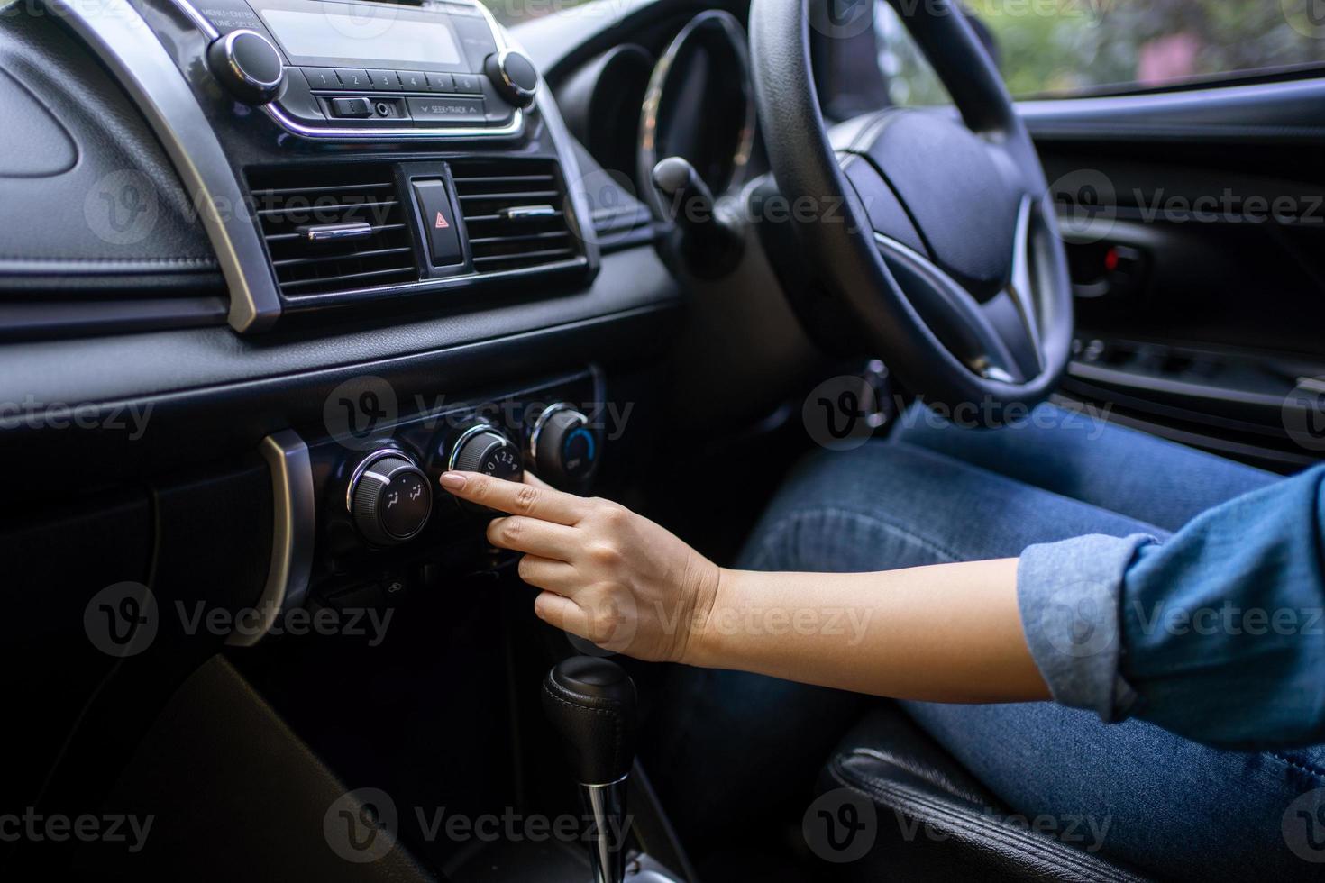 Turning on car air conditioning system. Hand tuning fm radio button in car panel. photo