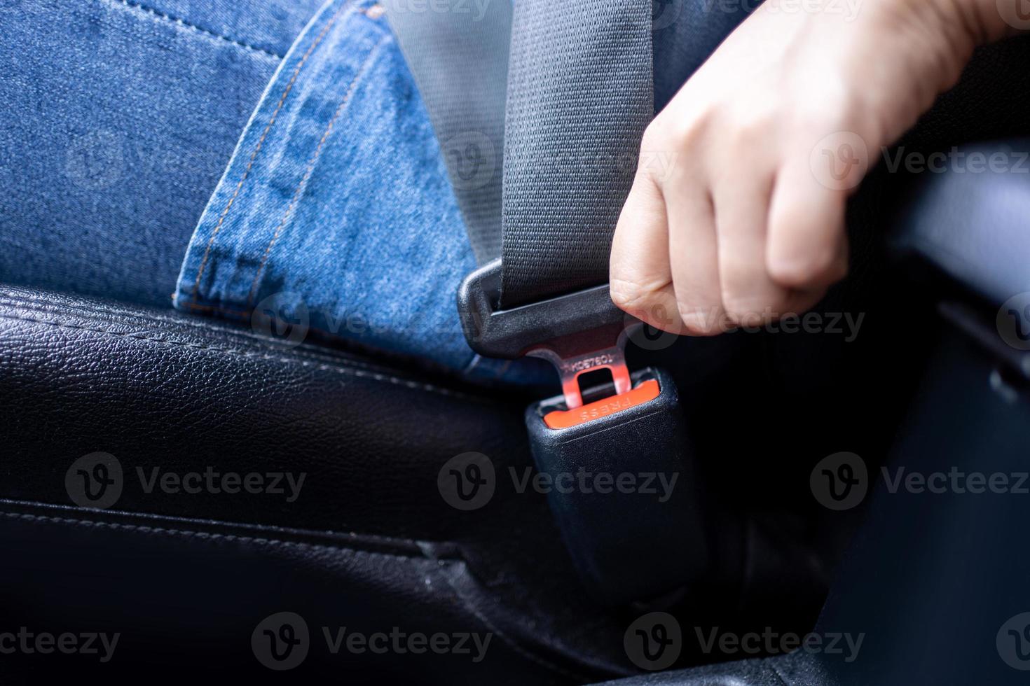 el primer plano de una conductora se abrocha el cinturón de seguridad antes de conducir. concepto de viaje seguro foto
