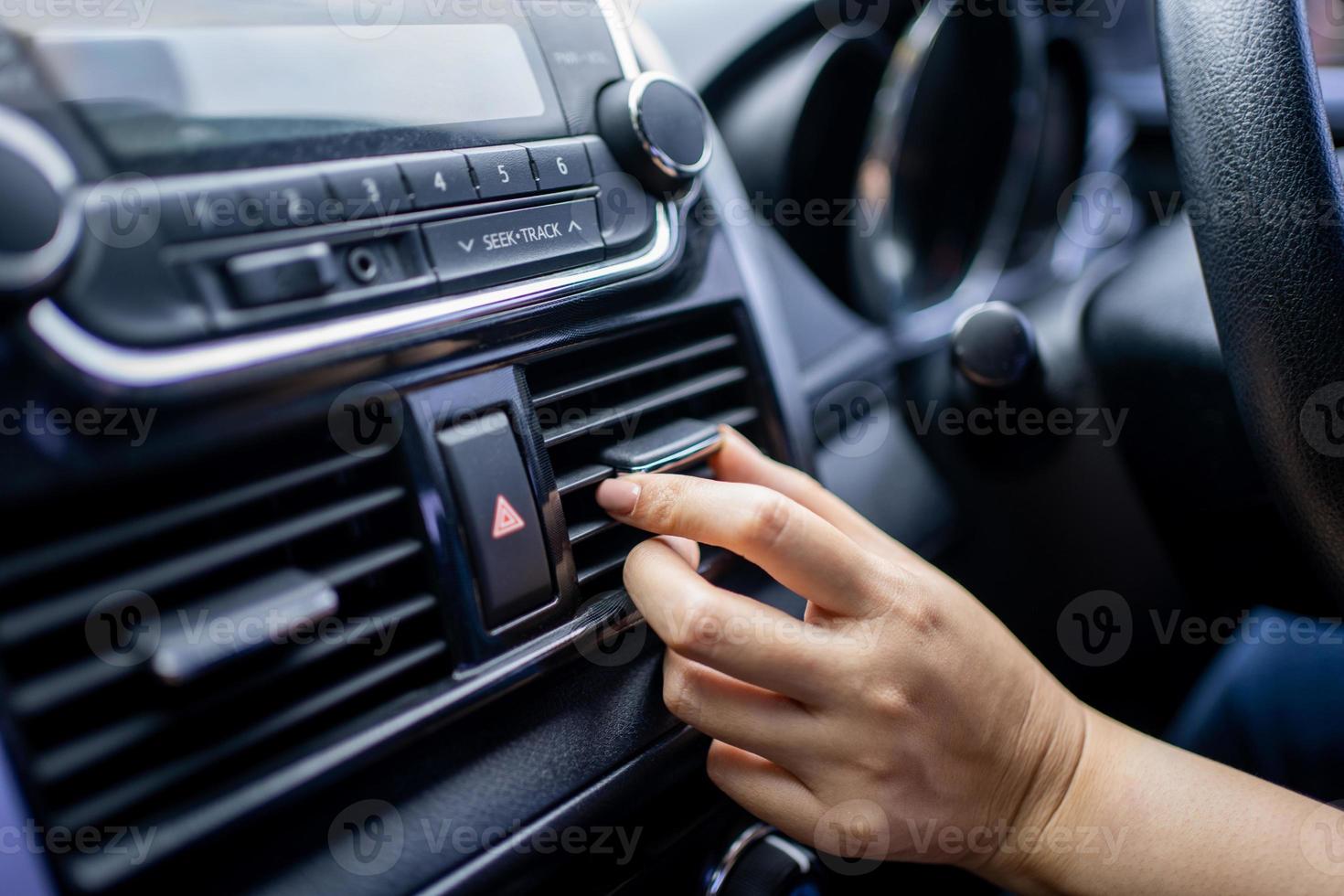 Close-up of the hand adjusting the air conditioning button in the car. photo