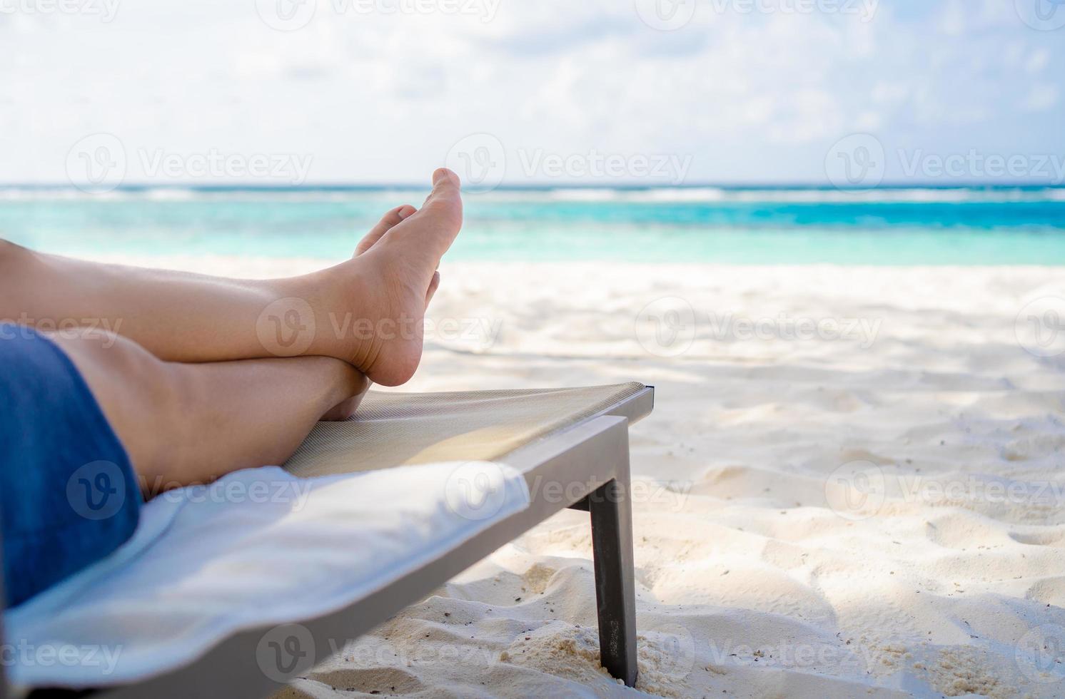 Man relaxing on beach chair at the beach. photo