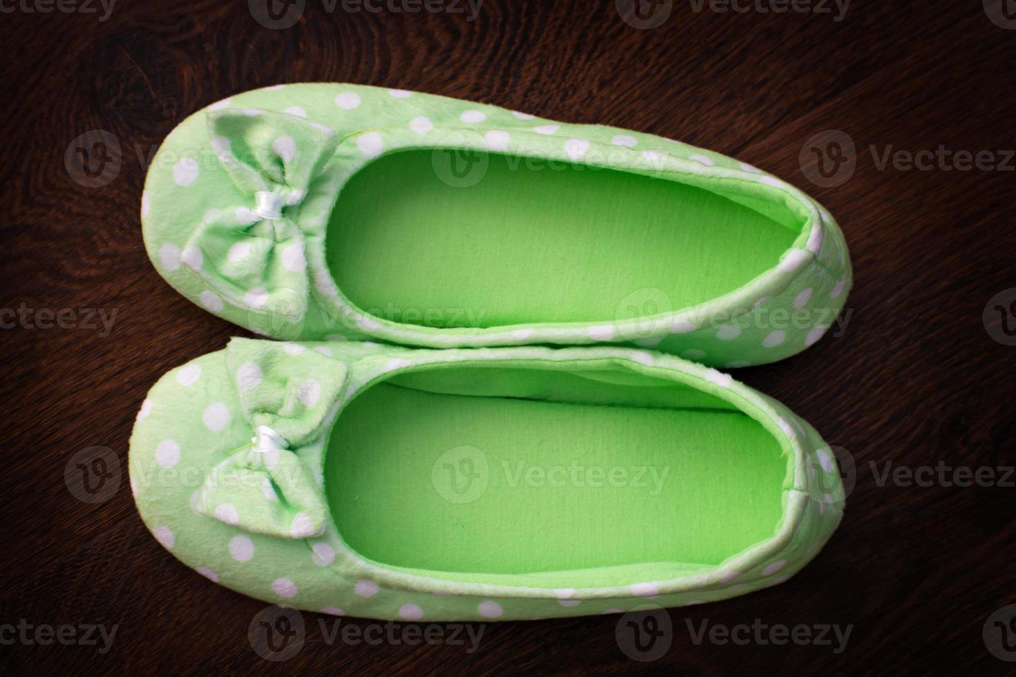 Female home green soft slippers on floor background photo