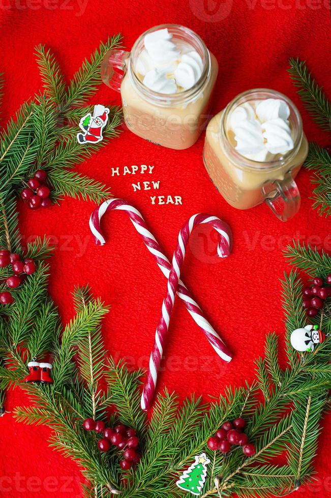 Closeup of marshmellou cocoa and candy on a red background. The inscription Happy New Year photo