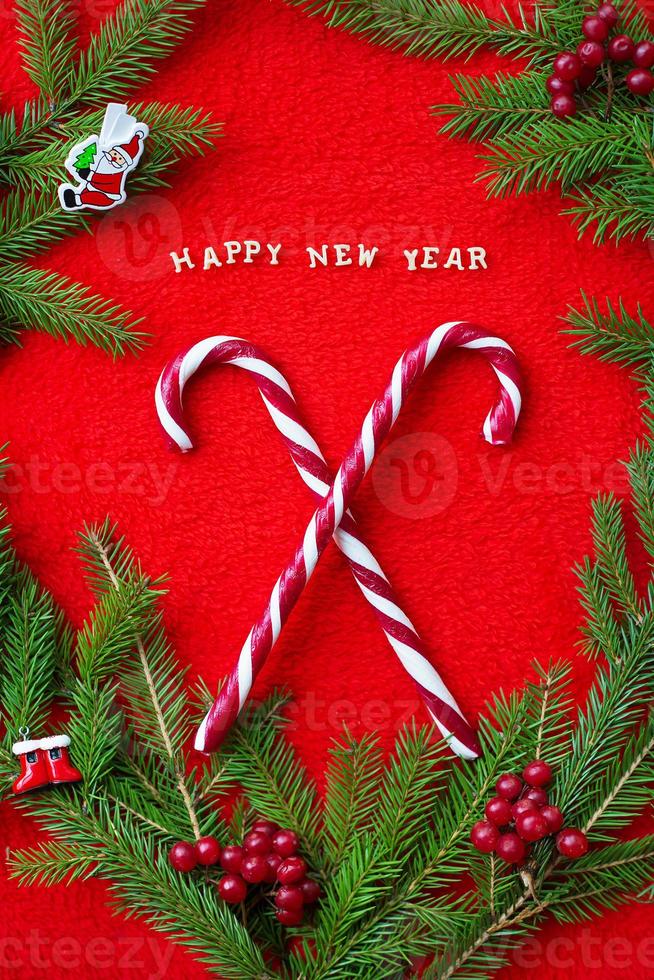 Christmas tree and candy on a red background with the words Happy New Year photo
