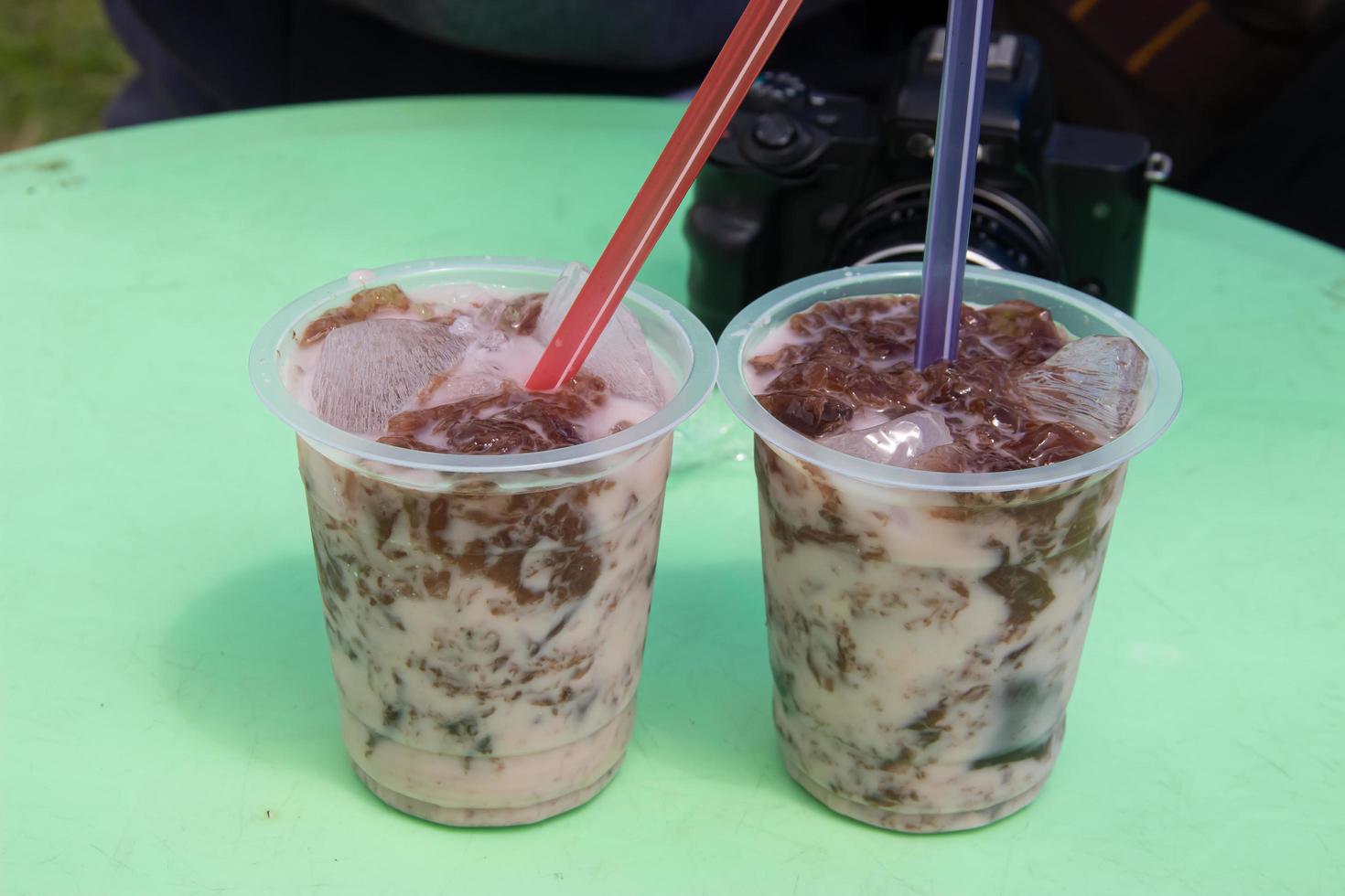 cold drink in a plastic container placed on a green table photo