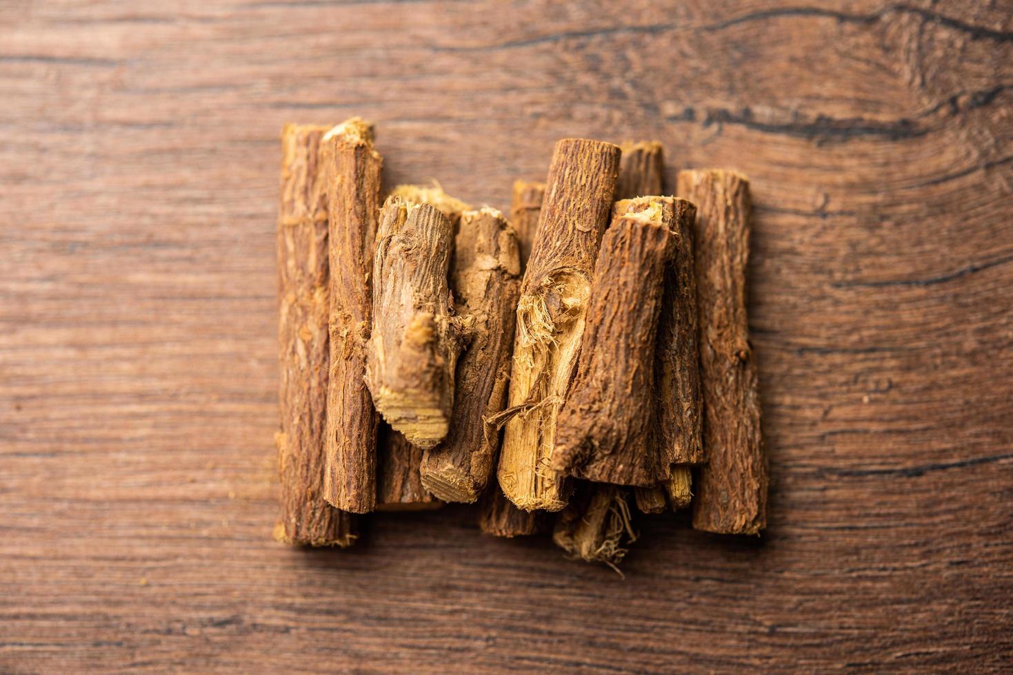 Ayurvedic Mulethi or Liquorice root stick or jeshthamadh powder served in a bowl over moody background photo