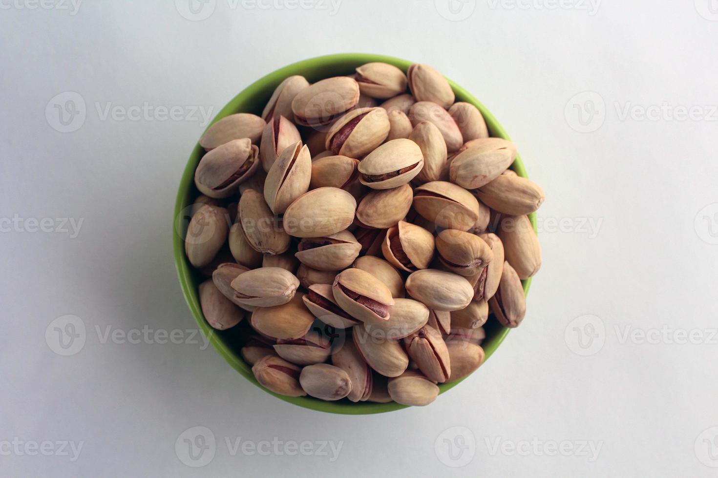 pistachio in shell nuts in a bowl on white background. photo