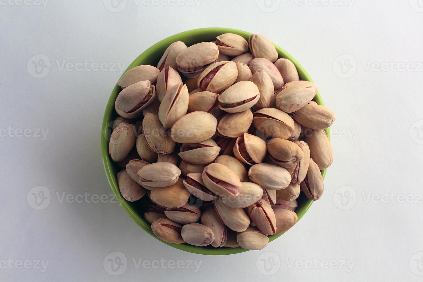 pistachio in shell nuts in a bowl on white background. photo