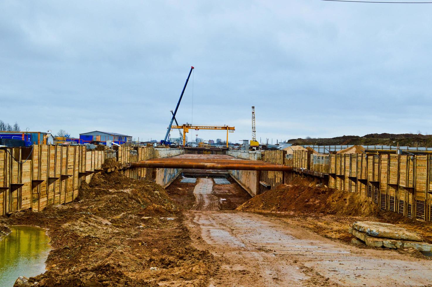 A construction site with specialized professional equipment and cranes during the construction of a modern line of the underground metro station in the big city of the metropolis photo