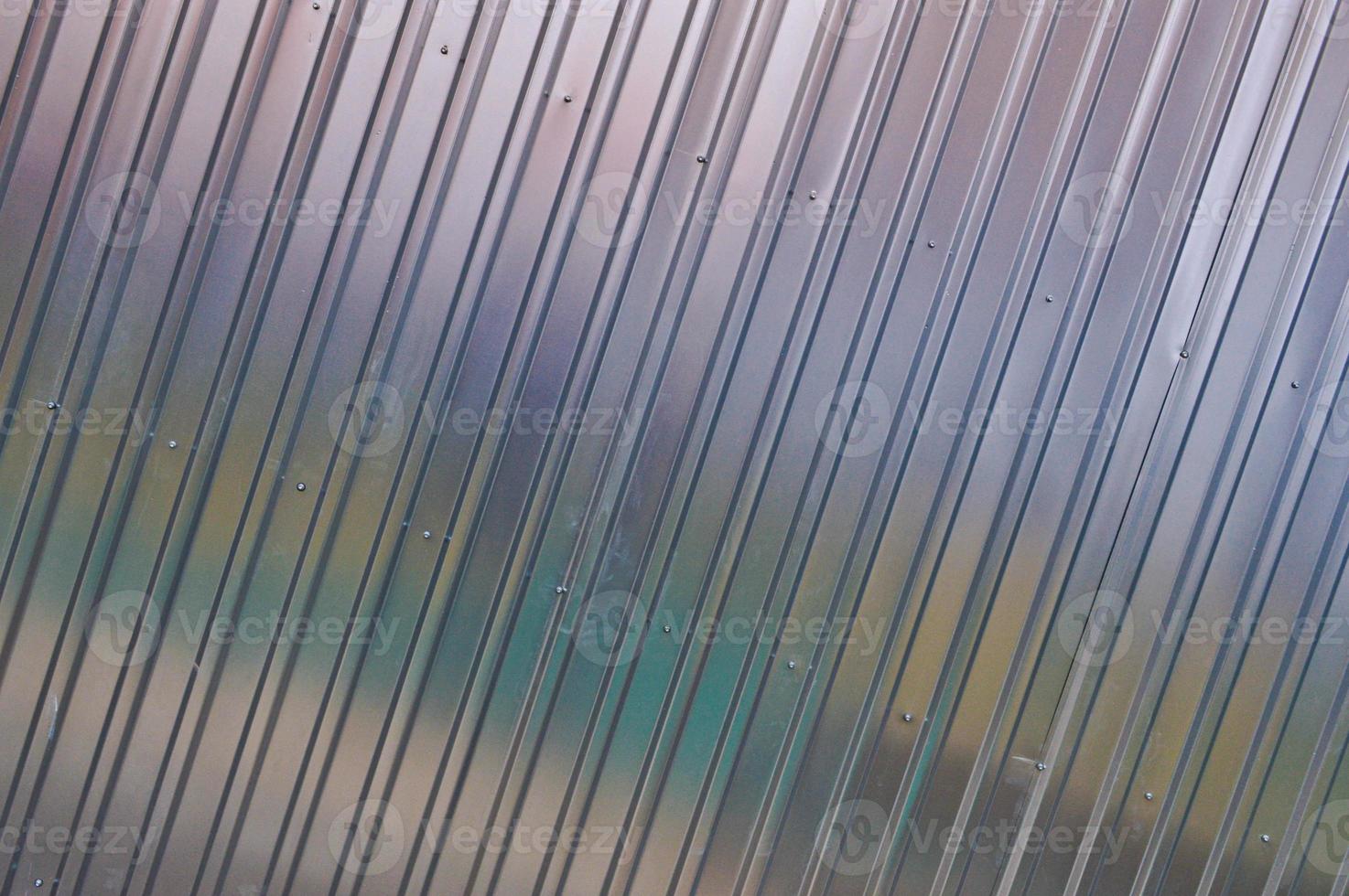 Silver tin iron wall with vertical and diagonal stripes from a metal profile of a metal sheet. Texture, background photo