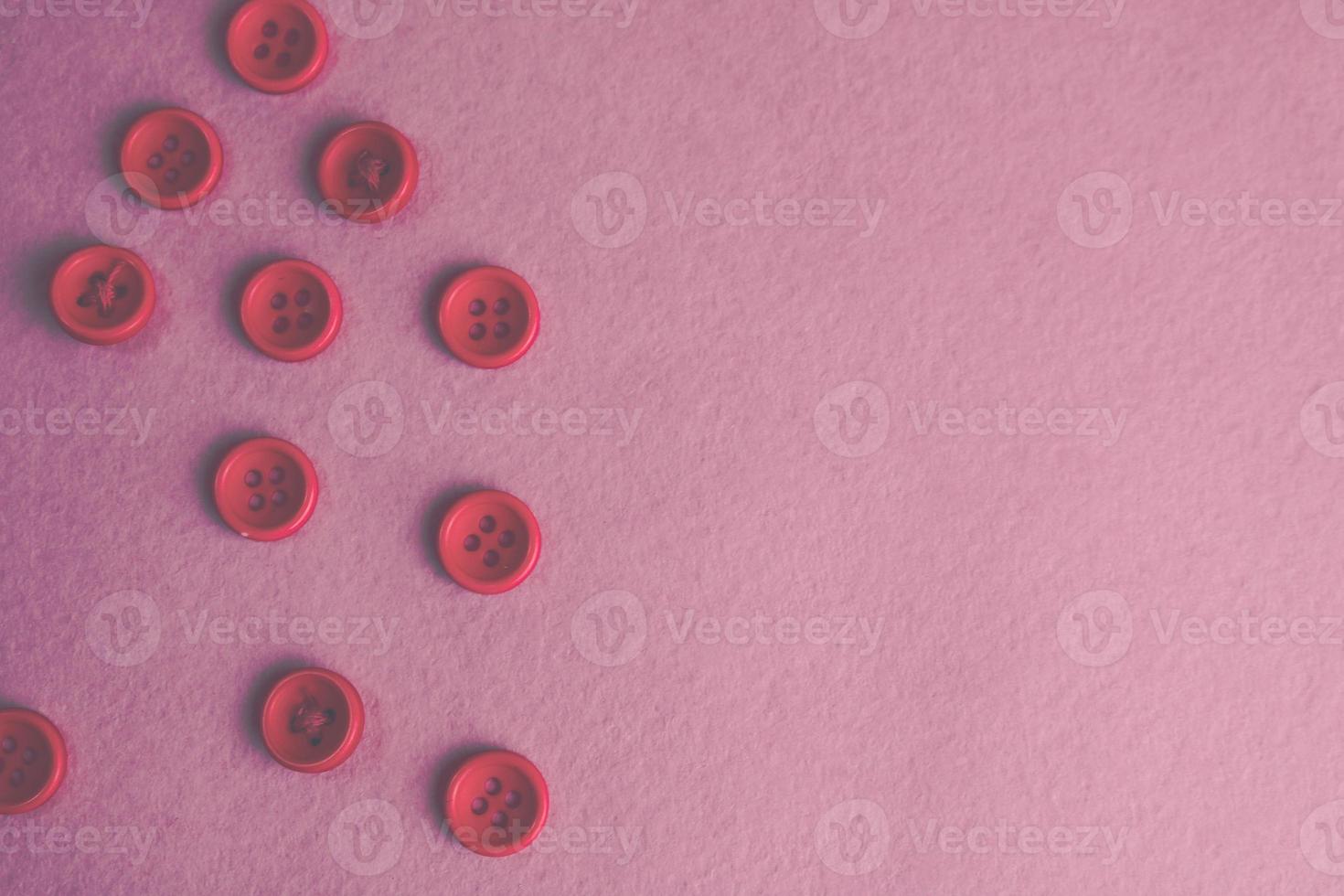 Beautiful texture with many round pink buttons for sewing, needlework. Copy space. Flat lay. Pink, purple background photo