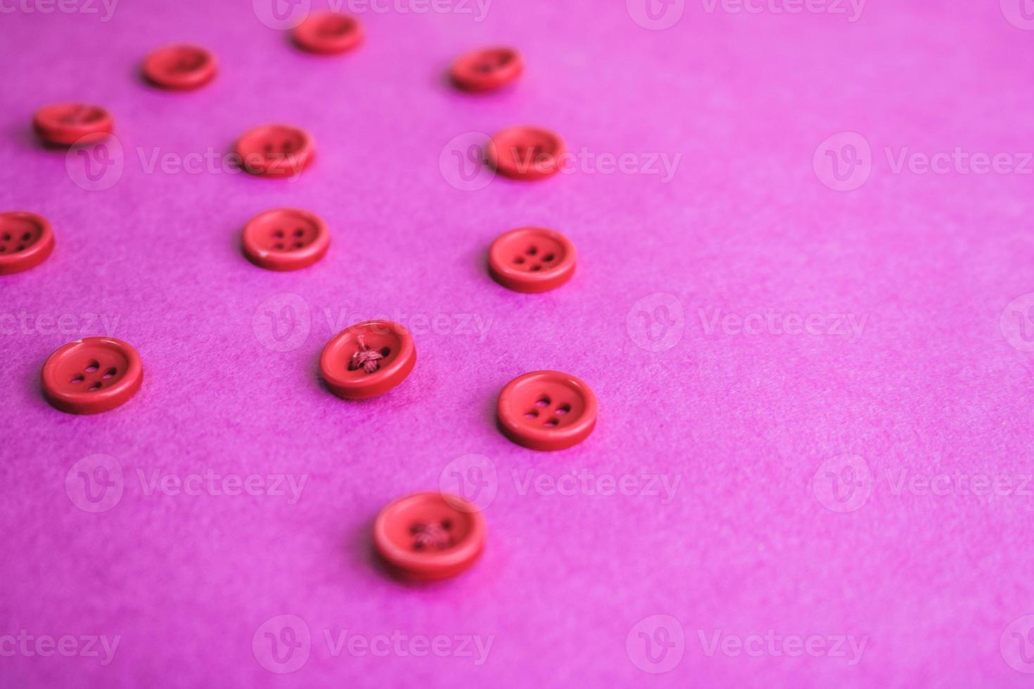 Beautiful texture with many round pink buttons for sewing, needlework. Copy space. Flat lay. Pink, purple background photo