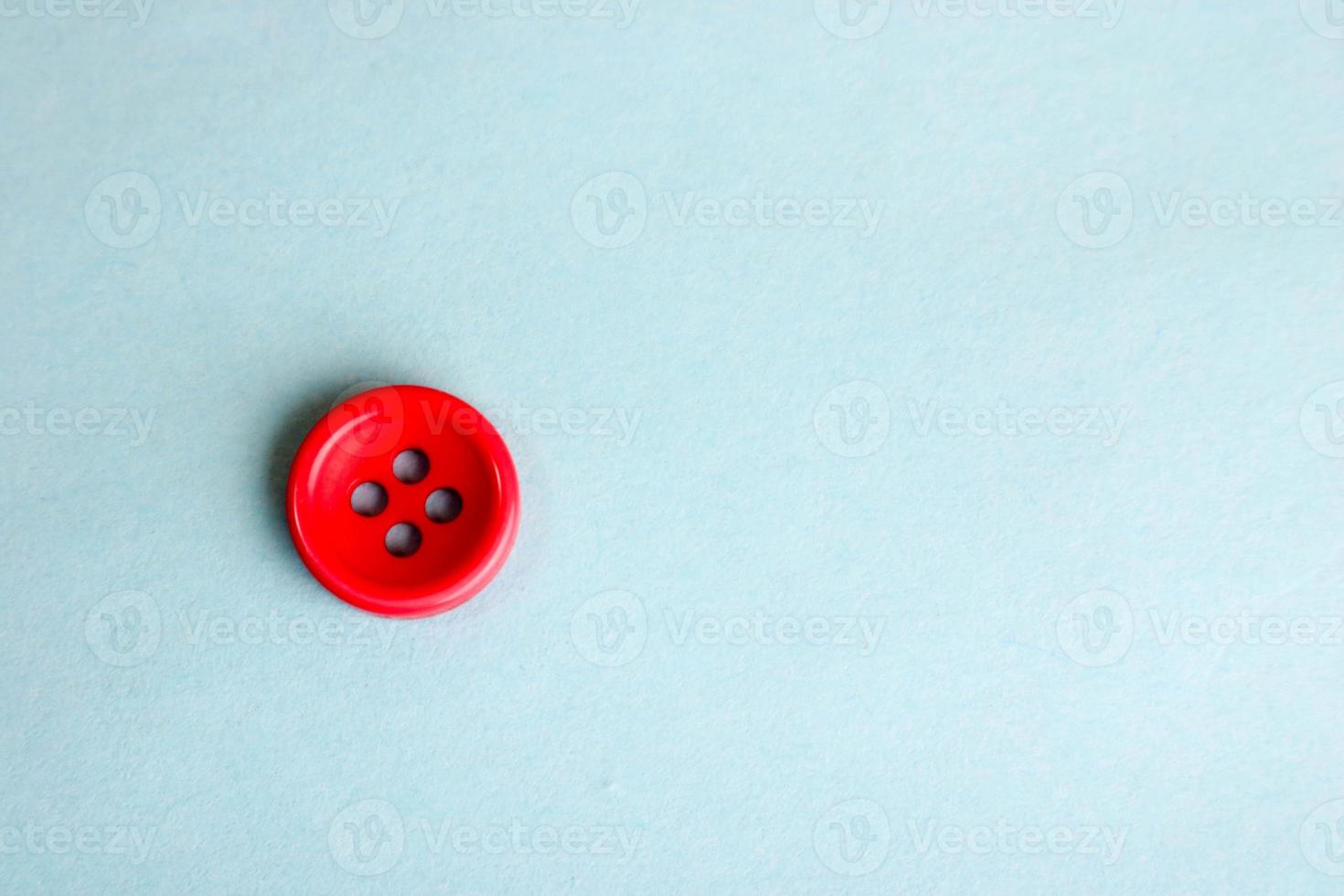 Beautiful texture with a round button for sewing, needlework. Copy space. Flat lay. Blue background photo