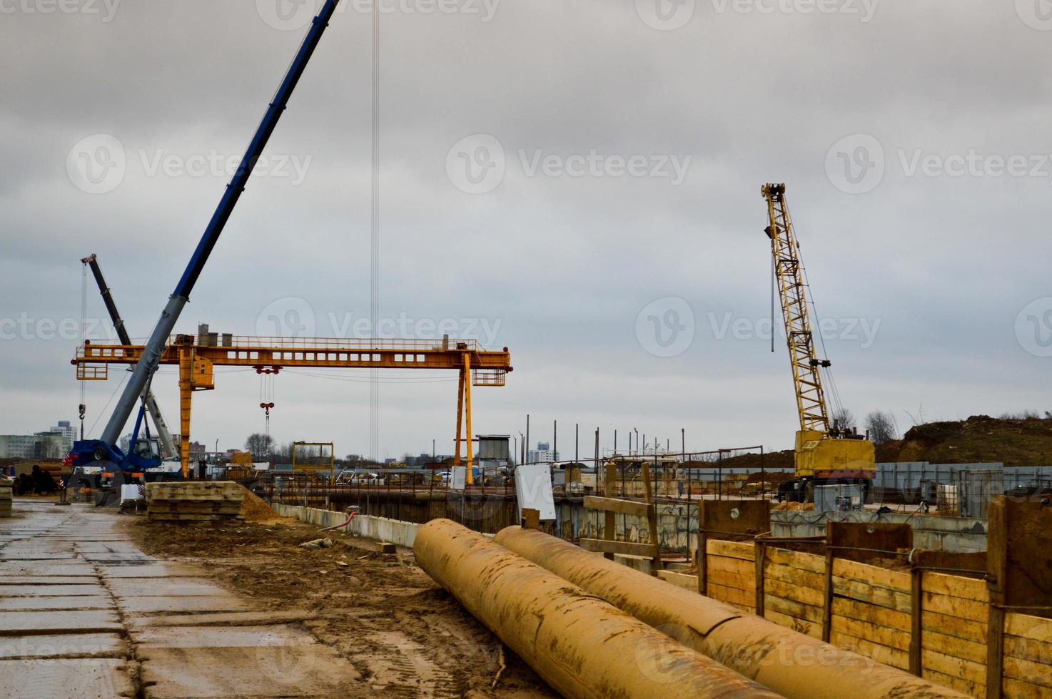 A construction site with specialized professional equipment and cranes during the construction of a modern line of the underground metro station in the big city of the metropolis photo