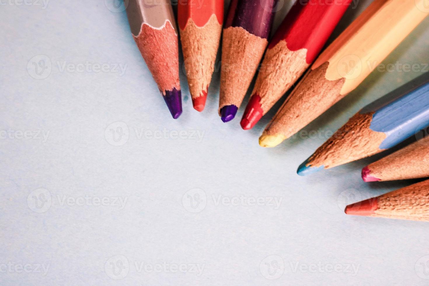 Beautiful bright colored wooden colored sharpening pencils for drawing. Flat lay and copy space on blue background photo