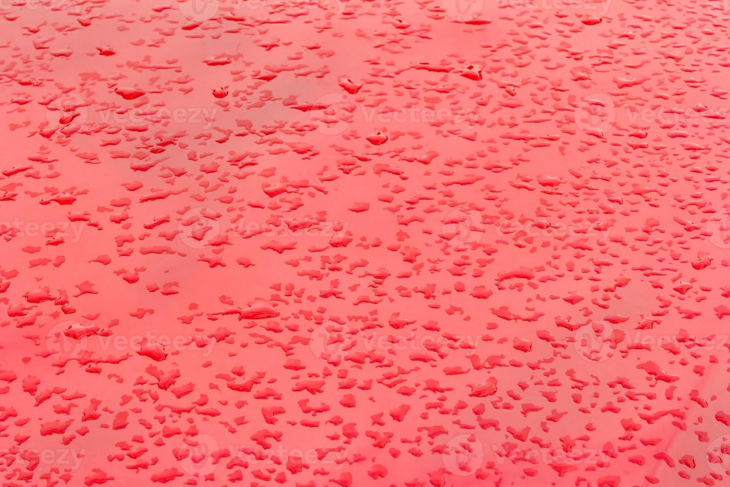 Drops of rain on red background. Natural Pattern of raindrops. photo