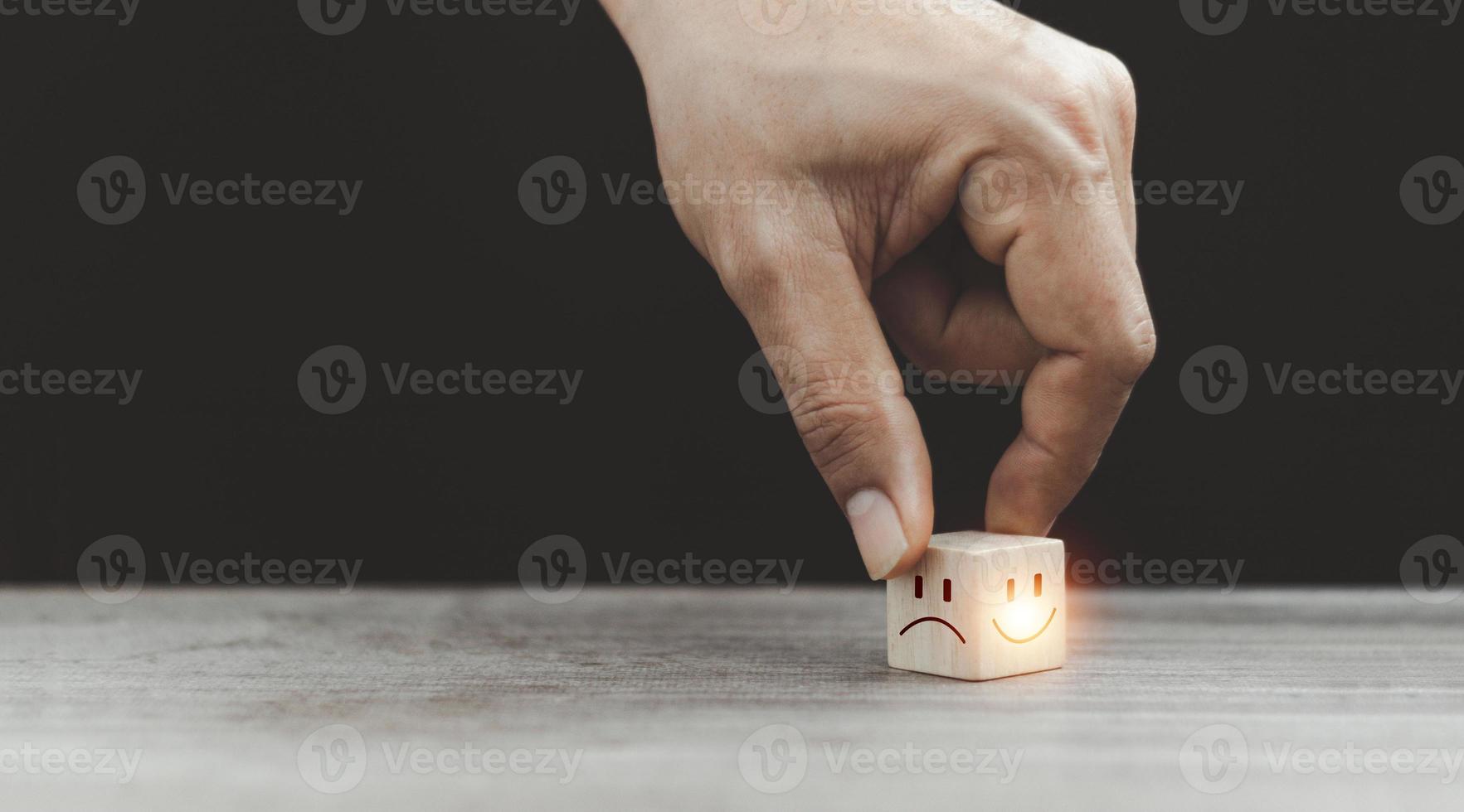Close up customer hand choose smiley face and sad face icon on wood cube, Service rating, satisfaction concept, copy space. photo
